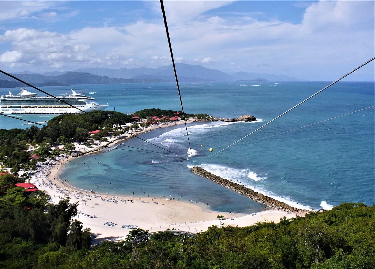 Bahía de Labadee vista desde lo alto: playa de arena blanca, mar turquesa y montañas al fondo.
